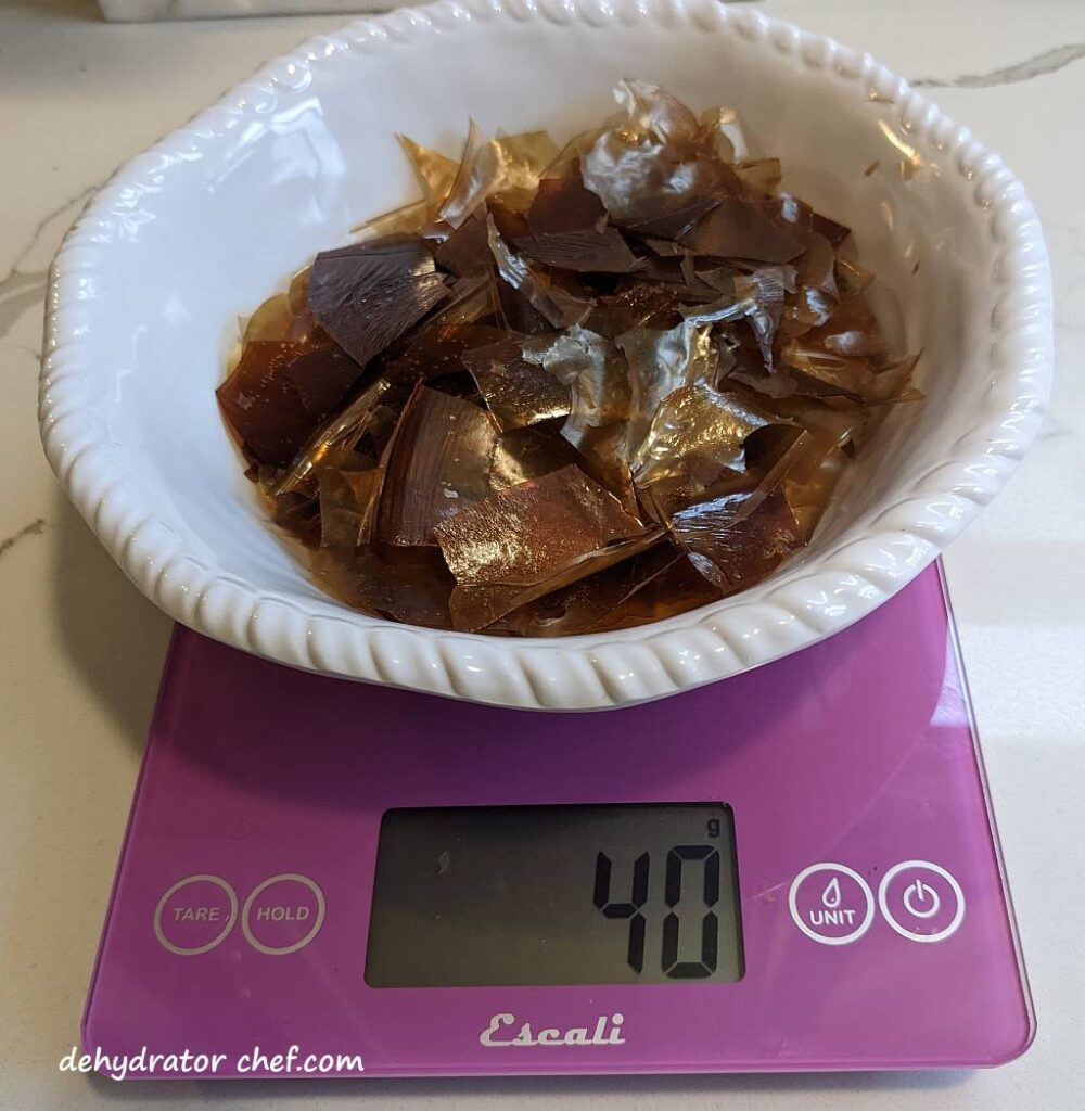 bowl of dehydrated beef stock shards on a scale weighing 40 grams