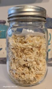 dehydrated onions in a clear canning jar with a desiccant packet for moisture control | dehydrating onions | drying onions