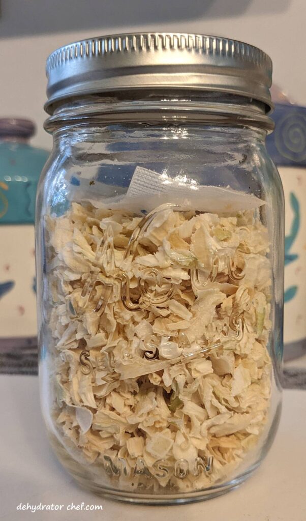dehydrated onions in a clear canning jar with a desiccant packet for moisture control | dehydrating onions | drying onions  | best foods to dehydrate for long term storage | dehydrating food for long term storage | dehydrated food recipes for long term storage | dehydrating meals for long term storage | food dehydrator for long term storage