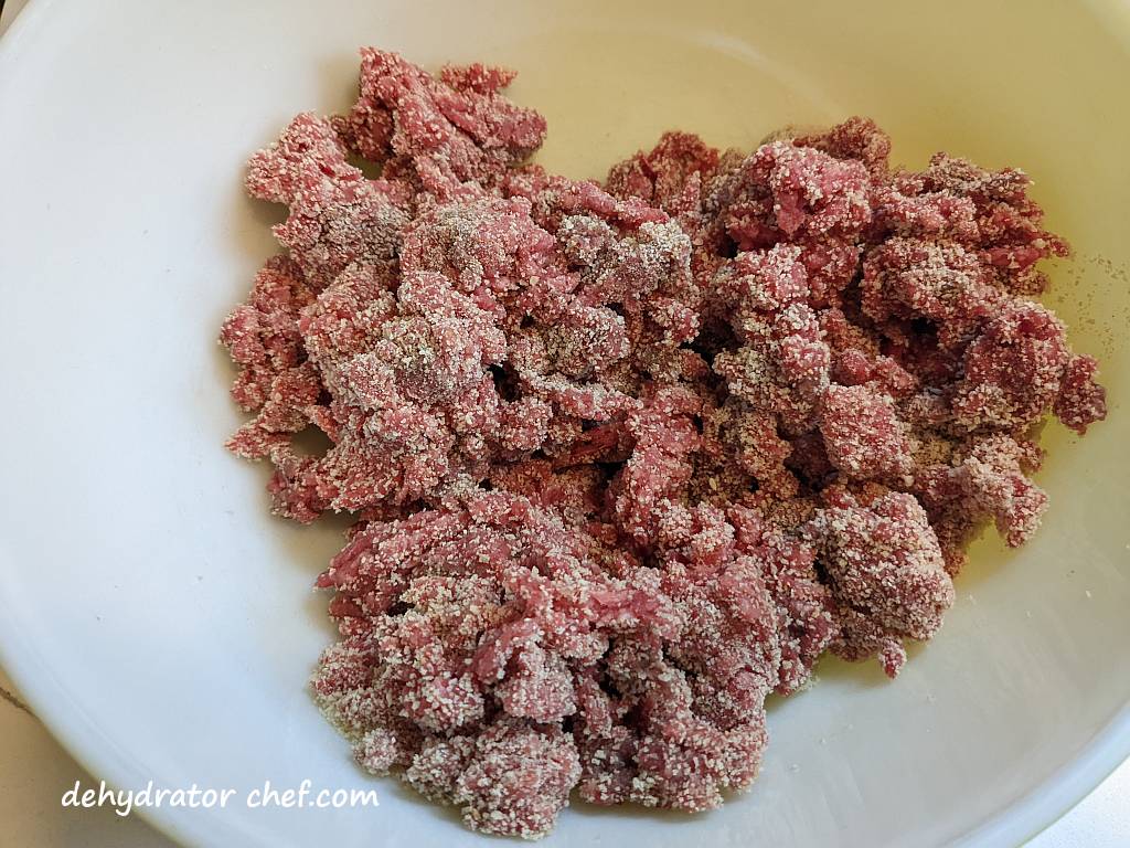 the inside of a mixing bowl showing the ground beef with breadcrumbs mixed in for our dehydrating ground beef recipe