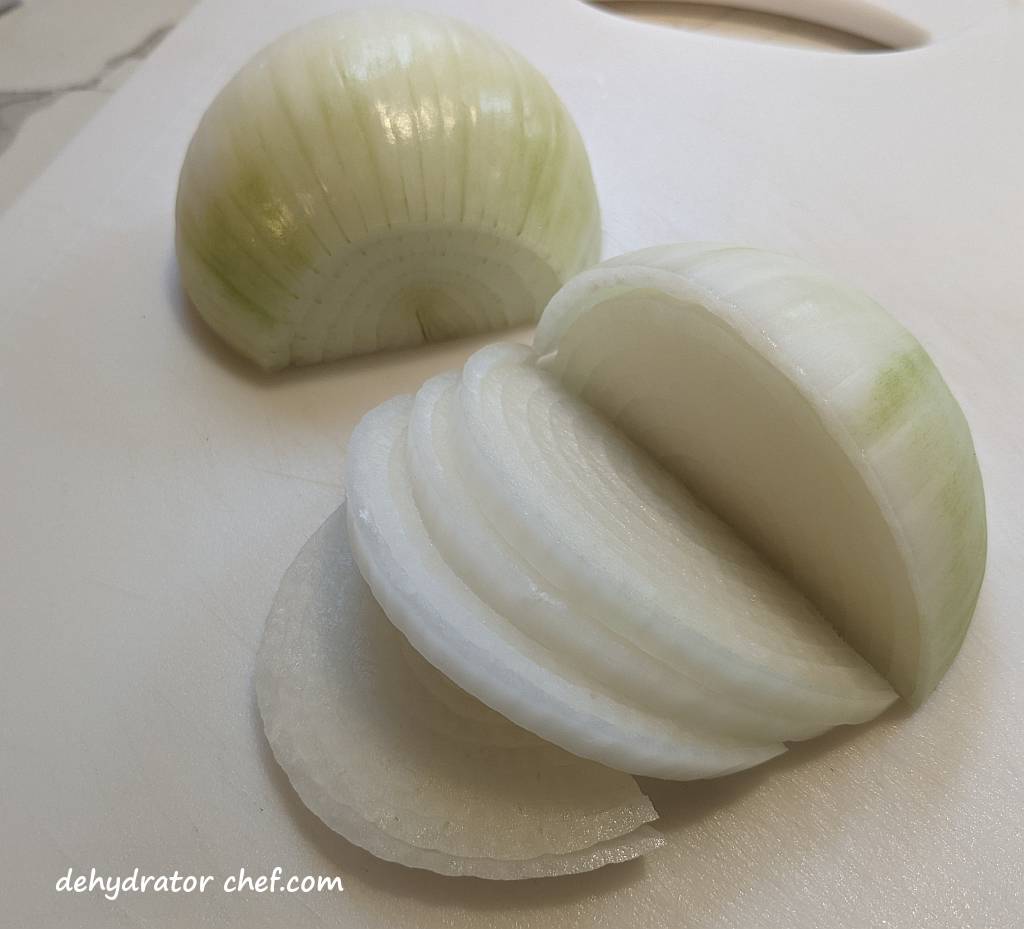 onion half rounds are being processed for dehydrating onions | dehydrated onions | drying onions  | best foods to dehydrate for long term storage | dehydrating food for long term storage | dehydrated food recipes for long term storage | dehydrating meals for long term storage | food dehydrator for long term storage 