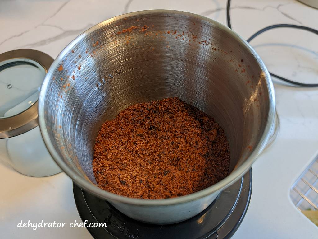 powdered chipotle peppers in adobo sauce in a spice grinder for use in our homemade dehydrated camping meals and daily cooking routine