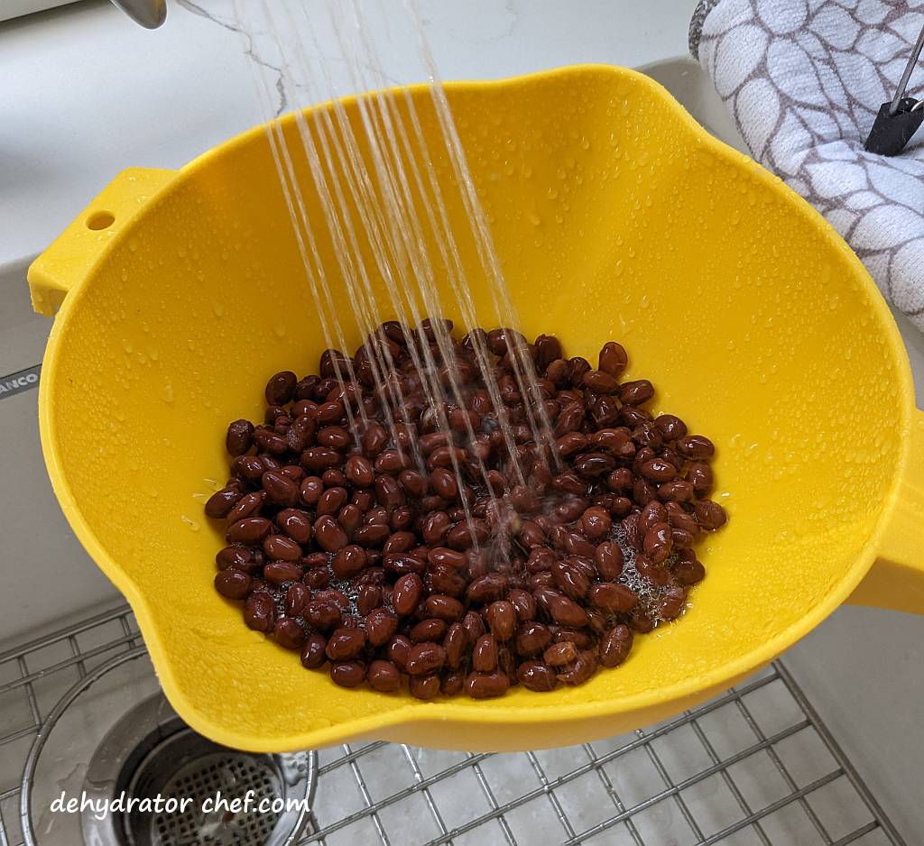 rinsing black beans in a colander