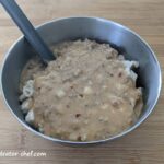 dehydrated biscuits and gravy in a stainless steel camping bowl with a long handle spoon | make your own dehydrated meals | homemade dehydrated backpacking meals