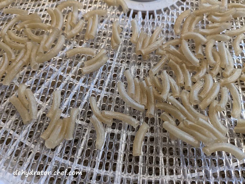 closeup of dehydrated macaroni on a dehydrator tray | | best foods to dehydrate for long term storage | dehydrating food for long term storage | dehydrated food recipes for long term storage | dehydrating meals for long term storage | food dehydrator for long term storage