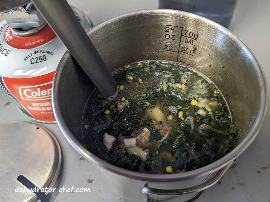 Showing the beef curry dry mix after it has hydrated for five or so minutes. We did top it off with some more water.  The hydrating ingredients will continue to absorb the liquid.  We are metering in the water a bit at a time so it doesn't end up too dry or soupy.  It might look like we have added too much water, but we have not. | Dehydrated beef curry. | Making dehydrated meals for camping. | Homemade dehydrated meal recipes. | How to make your own dehydrated camping food. | Homemade dehydrated camping meals. | Homemade dehydrated backpacking meals.