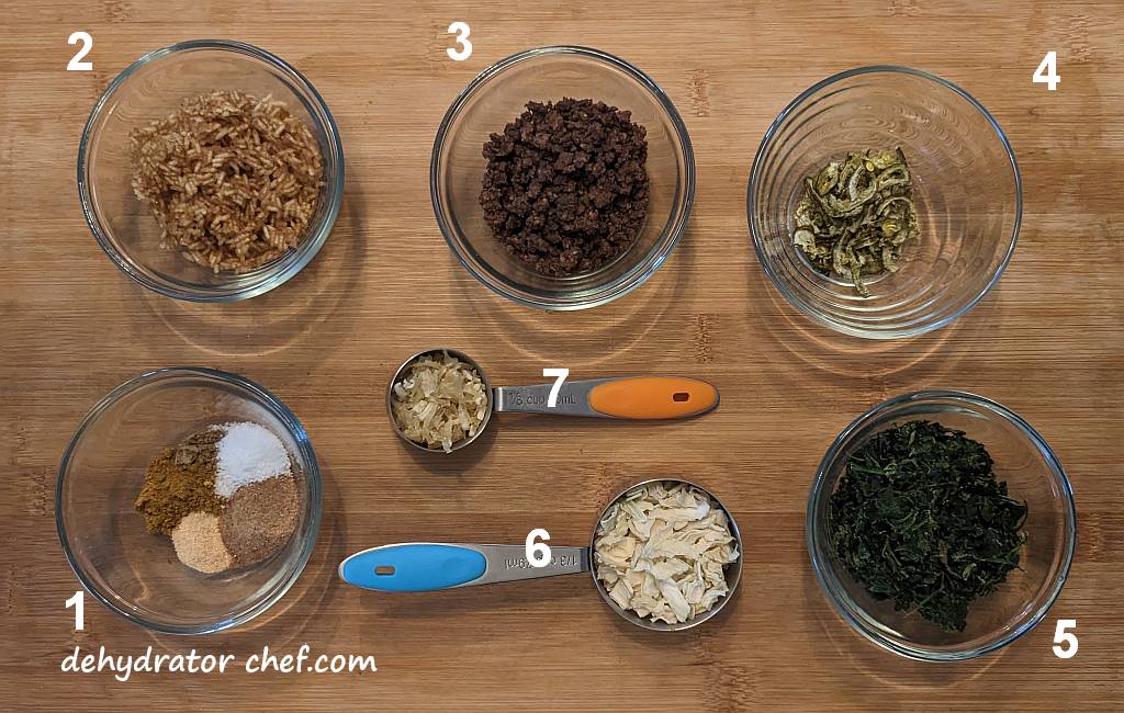 Shown are the ingredients needed for our dehydrated beef curry recipe.  From the lower left, clockwise, we have: one,  the spices, including, garlic powder, cumin powder, optional bouillon powder, and the star of the show, curry powder, two the dehydrated rice that was cooked in beef stock, three dehydrated ground beef crumbles, four the optional dehydrated jalapeno pepper slices, five dehydrated spinach, six dehydrated onion, and seven dehydrated cooked hash brown potatoes. | Dehydrated beef curry. | Making dehydrated meals for camping. | Homemade dehydrated meal recipes. | How to make your own dehydrated camping food. | Homemade dehydrated camping meals. | Homemade dehydrated backpacking meals.