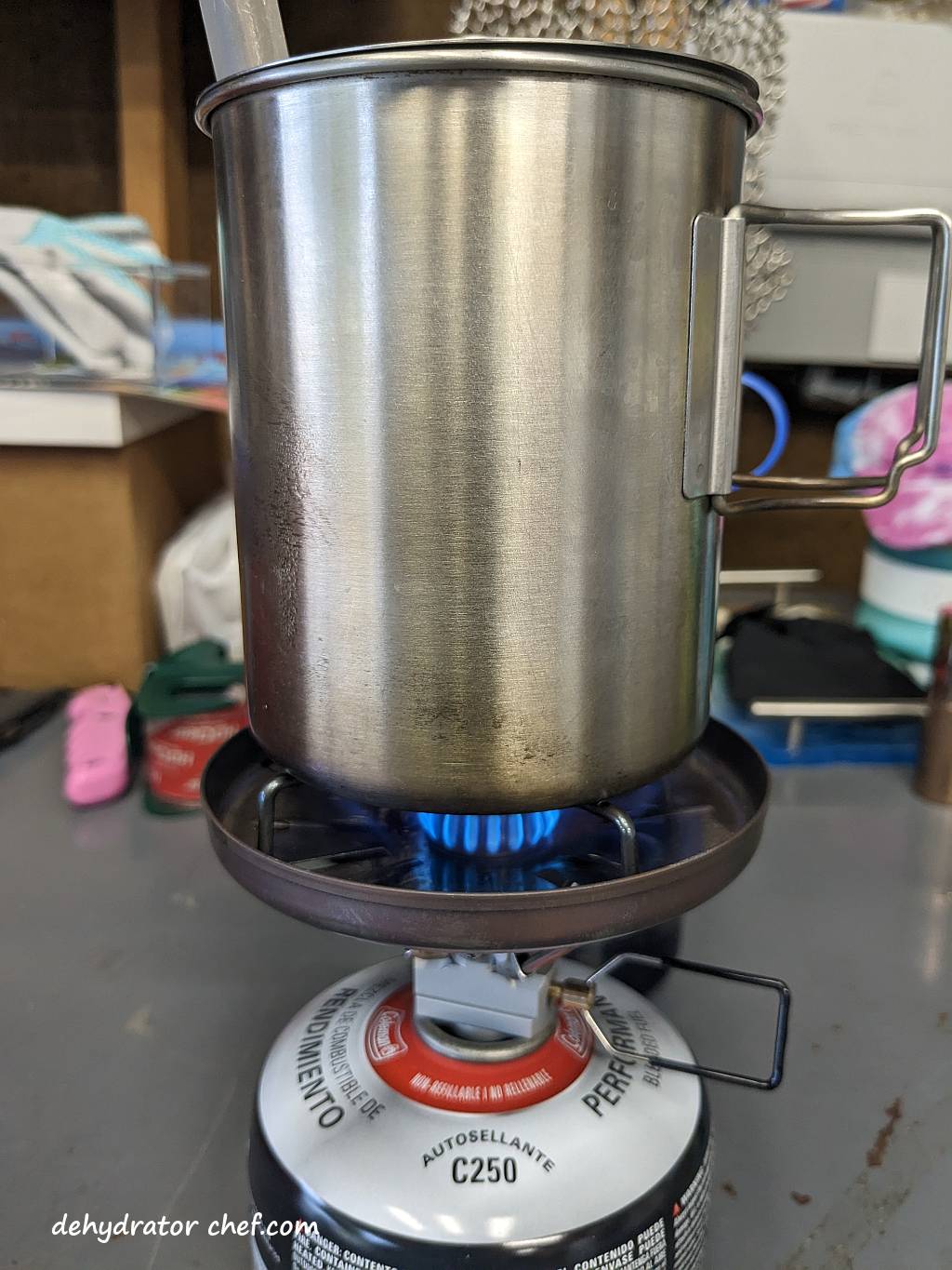 Shown is a single burner camping stove with a cooking pot on top.  We’re bringing the beef curry mix to a boil. | Making dehydrated meals for camping. | Homemade dehydrated meal recipes. | How to make your own dehydrated camping food. | Homemade dehydrated camping meals. | Homemade dehydrated backpacking meals.