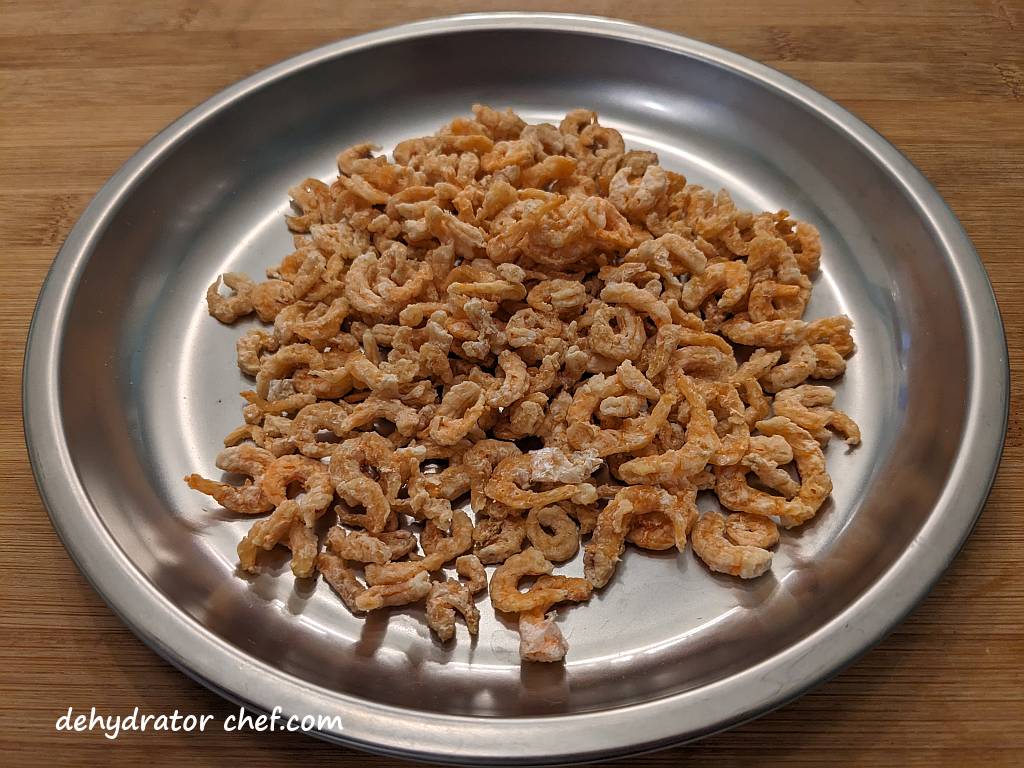 dried shrimp on a metal camping plate | dehydrating shrimp | how to dehydrate shrimp | best foods to dehydrate for long term storage | dehydrating food for long term storage | dehydrated food recipes for long term storage | dehydrating meals for long term storage | food dehydrator for long term storage | making dehydrated meals for camping | homemade dehydrated meal recipes | make your own dehydrated camping food | homemade dehydrated camping meals | homemade dehydrated backpacking meals