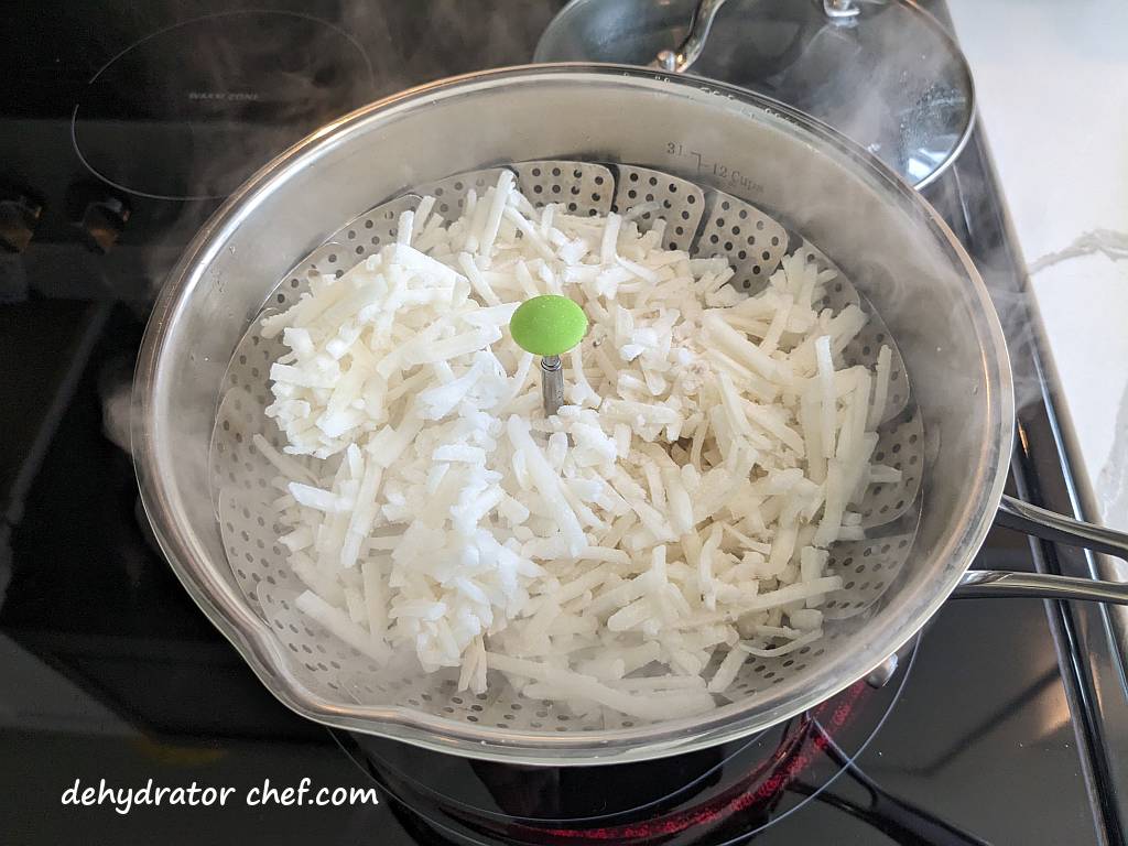 https://dehydratorchef.com/wp-content/uploads/2023/06/steam-cooking-the-shredded-hash-brown-potatoes-for-a-few-minutes.jpg