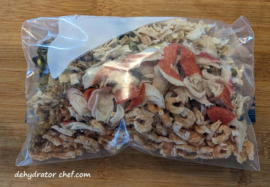 Shown is the dehydrated seafood curry dry mix inside a zip-top bag. This is a compact, lightweight, and easy-to-carry homemade dehydrated camping meal.  | Dehydrated seafood curry dry mix in a zip top bag. | Dehydrated seafood curry | Making dehydrated meals for camping | Homemade dehydrated meal recipes. | How to make your own dehydrated camping food. | Homemade dehydrated camping meals. | Homemade dehydrated backpacking meals.