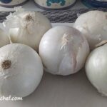 several pounds of white onions on cutting board | dehydrating onions | dehydrated onions | best foods to dehydrate for long term storage | dehydrating food for long term storage | dehydrated food recipes for long term storage | dehydrating meals for long term storage | food dehydrator for long term storage