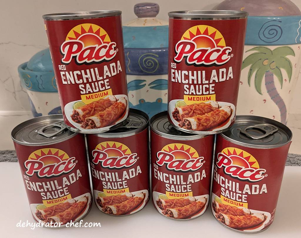 For today's dehydrator project, we have six 10.5-ounce cans of Pace red enchilada sauce. We're running low and need to restock our supply. Enchilada sauce is a great addition or substitution ingredient to take any of your dehydrated camping food recipes up a flavor notch or two. These six 10.5-ounce cans will fill up two 1-quart canning jars leaving sufficient headspace needed to equalize and condition in later steps.