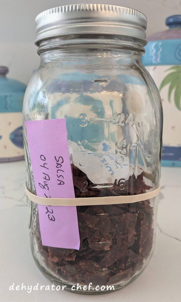 This is two dehydrated 16-ounce jars of Pace Chunky Salsa.  It all fits nicely into a one-quart clear canning jar.  Dehydrated salsa is one of the best foods you can dehydrate for long-term storage.  We have added a 5-gram desiccant packet for moisture control and to help extend the shelf life.  Properly stored, this jar would last at least 12 months.  But we'll use it all long before then.