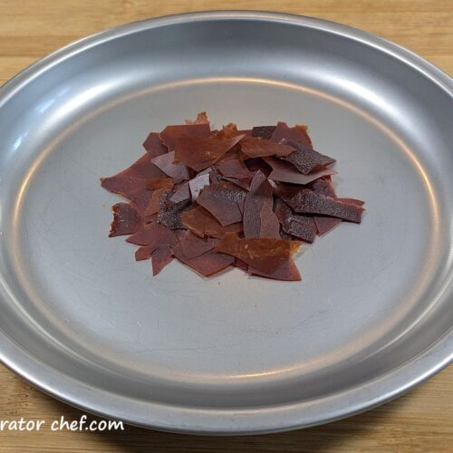 One 7 gram serving of dehydrated tomato sauce on a plate.