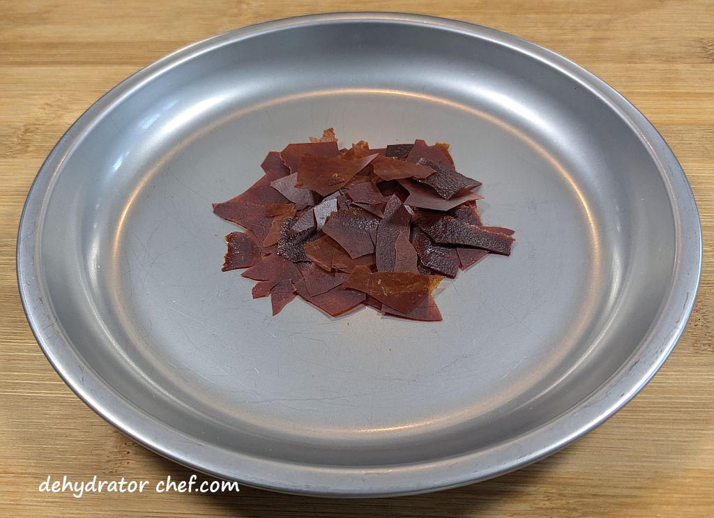 One 7 gram serving of dehydrated tomato sauce on a plate.