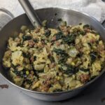 Shown is a bowl of dehydrated beef curry recipe that makes for a flavorful, shelf-stable meal that’s easy to prepare out in the field or at the campsite. Ground beef crumbles, rice cooked in beef stock, and RoTel Diced Tomatoes with Green Chilies form the base, while onion, spinach, and hash brown potatoes add texture. A blend of spices like garlic, cumin, and curry powder brings depth, with optional bouillon powder and jalapeno slices for an extra bit of flavor.