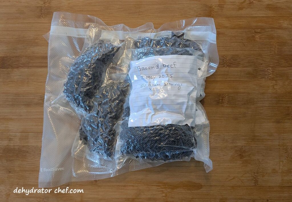 We put all of the 50-gram single-serving vacuumed-sealed packets of dehydrated ground beef into a larger vacuumed sealed bag. We’re going to put this all into our freezer for long term storage. When we want to build out a few homemade camping meals, all we need to do is open the bag, grab what we need, and let them warm up. They’re ready to go.