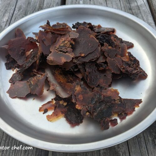 Dehydrated chipotle peppers in adobo sauce on a plate, ready for long-term storage and use in homemade backpacking meals.