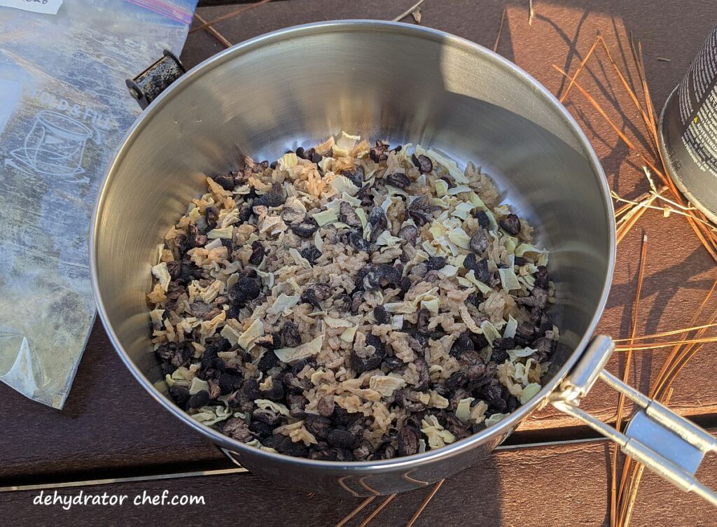 The dehydrated black beans and rice dry mix has been emptied into the cooking pot. Next we’ll add in enough water to cover the ingredients and let it rest for 5 or 10 minutes while we get camp set up. We’ll probably need to top off the water before we start cooking because the dry ingredients will absorb a lot of this water.
