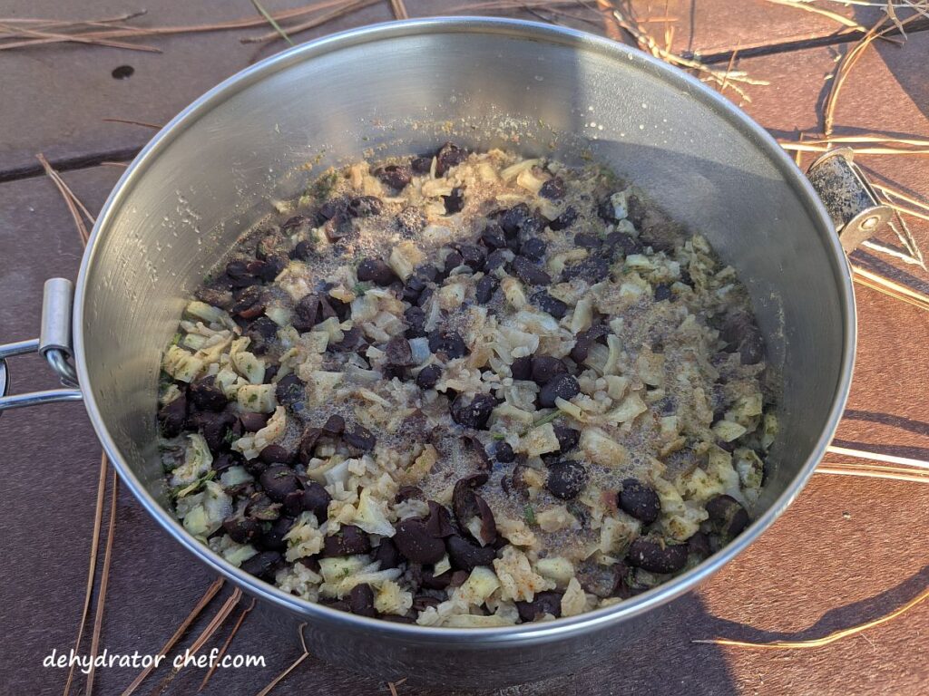 The black beans and rice have finished cooking and steaming. Next, we’ll drizzle on some avocado oil to enhance the flavor and stir it all together to fluff up the mix.